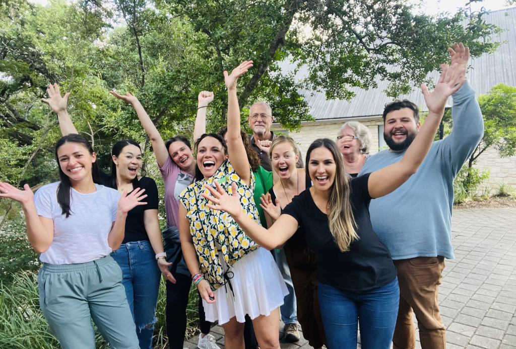 group of mental health professionals celebrating by throwing their hands in the air